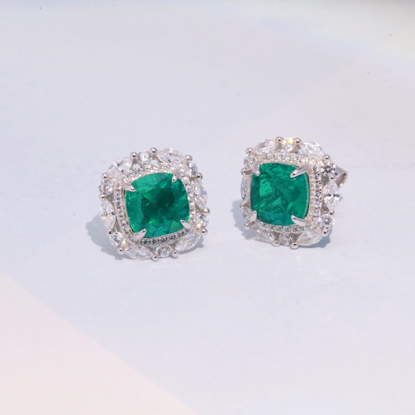 emerald stud earring features a silver setting with gold plating emerald stud earring features a silver setting with gold plating