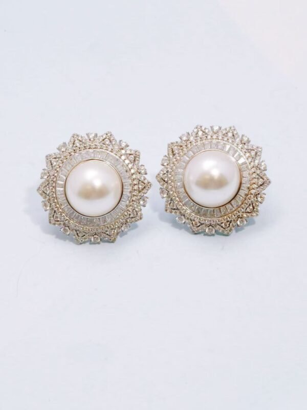 a pair of earrings with pearls and diamonds